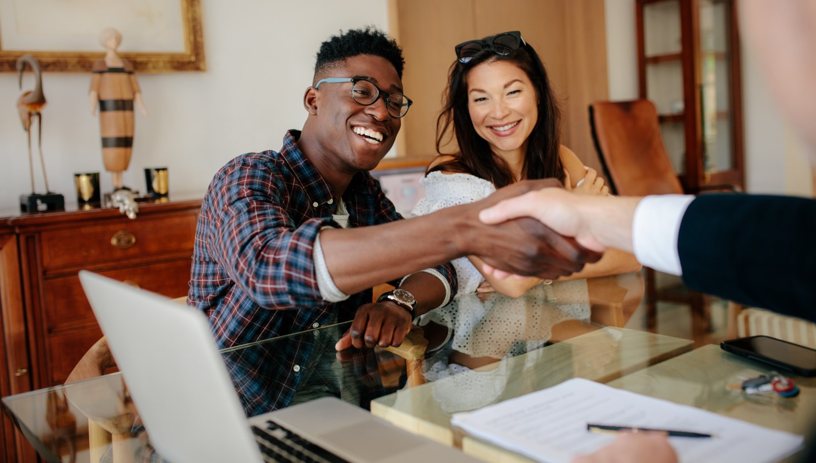 Couple-handshaking-realtor-after-signing-contract